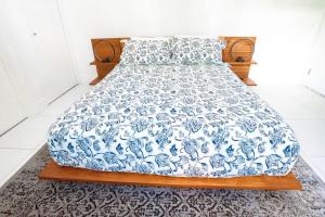 a bed with a blue and white comforter on it at Across the Ocean few steps to beach contemporary three Bedroom townhouse in Pompano Beach