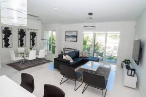 a living room with a couch and a table and chairs at Across the Ocean few steps to beach contemporary three Bedroom townhouse in Pompano Beach