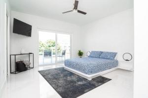 a white bedroom with a bed and a rug at Across the Ocean few steps to beach contemporary three Bedroom townhouse in Pompano Beach +73 photos