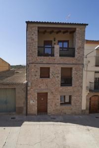 um edifício de tijolos com uma varanda em cima em La Casa del Lino em Torrebeses