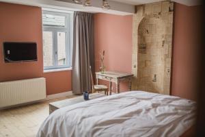 a bedroom with a large bed and a shower at Le Mayou in Mortroux