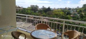 einen Tisch und Stühle auf einem Balkon mit Stadtblick in der Unterkunft Bombinhas Summer Beach - Apto 303 in Bombinhas