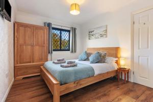 1 dormitorio con cama y ventana en Hazelglade Cottage - Hot Tub, Games Room, Pet Friendly en Saundersfoot