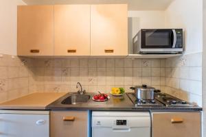 a kitchen with a sink and a microwave at Résidence Pierre & Vacances Les Jardins de la Côte d'Azur in Saint-Mandrier-sur-Mer