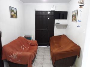a room with two chairs and a black door at Magistério para veraneio e descanso in Pinhal