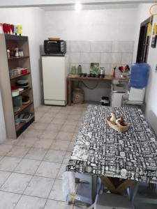 a kitchen with a table and a refrigerator at Magistério para veraneio e descanso in Pinhal