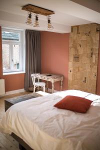 a bedroom with a large bed and a table at Le Mayou in Mortroux