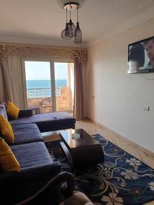 a living room with a couch and a view of the ocean at Sea point apartment in Alexandria