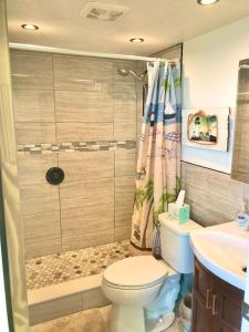 a bathroom with a toilet and a shower and a sink at Just Beachy -Ocean View at Symphony Beach Club in Ormond Beach