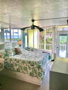 a bedroom with a bed and some windows at Just Beachy -Ocean View at Symphony Beach Club in Ormond Beach