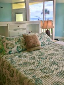 a bedroom with a large bed with a window at Just Beachy -Ocean View at Symphony Beach Club in Ormond Beach