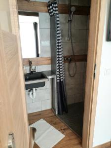 a bathroom with a sink and a shower with a shower curtain at BoomerangHouse in Wrocław