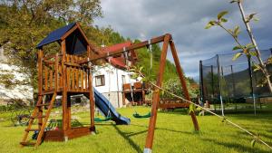 a wooden playground with a slide and a swing at Agroturystyka Corno Owca in Żabnica