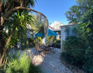 a patio with two chairs and a blue umbrella at Antonine Apartment Upper Garden District in New Orleans