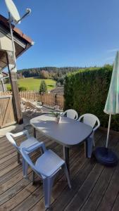 einen Tisch und Stühle auf einer Holzterrasse in der Unterkunft Duplex de charme avec terrasse in Les Hôpitaux-Neufs