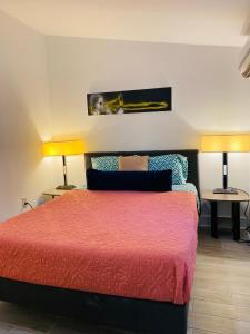 um quarto com uma cama e duas lâmpadas em duas mesas em Antonine Apartment Upper Garden District em Nova Orleans