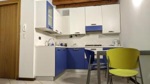 a kitchen with blue and white cabinets and green chairs at Ca' degli Sposi in Mantova