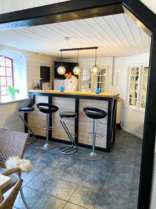 a kitchen with a bar with three stools at BB Esbjerg in Esbjerg
