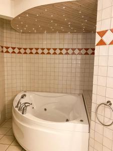 a bath tub in a bathroom with a tiled wall at BB Esbjerg in Esbjerg