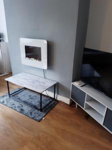 a living room with a coffee table and a tv at Modern property close to Aintree Hospital & Motorways in West Derby