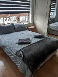 a bed with two pillows on it in a bedroom at Modern property close to Aintree Hospital & Motorways in West Derby