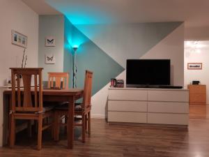 a dining room with a table and a television at Cosy Apartment with Balcony in Herne Bay
