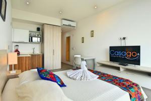 a living room with a bed and a tv at Menesse the City by Casago in Playa del Carmen +51 photos