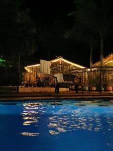 a bench sitting next to a pool at night at Villa del Sol Hotel & Restaurante in Villavieja +7 photos