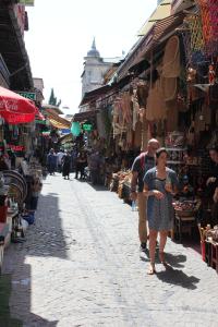 a man and a woman walking down a street in a market at Reydel Hotel in Istanbul