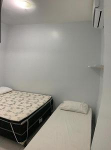 a bedroom with two beds in a white room at Winterville Flats & Bangalôs Gravatá in Gravatá +14 photos