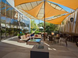 un patio con mesas y sombrillas en un edificio en Hotel Director Vitacura, en Santiago
