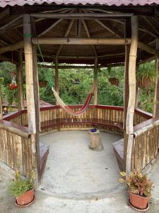 a hammock in a wooden pavilion with a tree stump at Can Jam Retreat in Negril