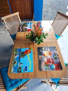 a wooden table with two books and a plant on it at Villa charmante au Moule avec piscine in Le Moule