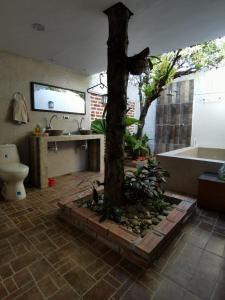La salle de bains est pourvue d'un arbre et d'une baignoire. dans l'établissement Villa del Sol Hotel & Restaurante, à Villavieja