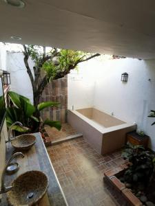 baño con bañera y 2 lavabos y plantas en Villa del Sol Hotel & Restaurante, en Villavieja