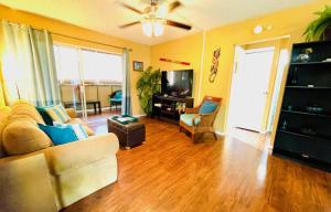 a living room with a couch and a television at Palani Condo in Kailua-Kona