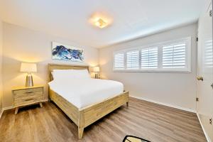- une chambre avec un lit blanc et une fenêtre dans l'établissement Newport Beach House, à Newport Beach