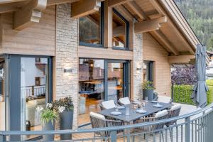 a deck with a table and chairs on a house at Alpenchalet Tirol in Längenfeld