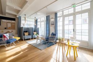 a living room with chairs and tables and windows at Pierre & Vacances Premium Résidence de la Plage in Le Crotoy