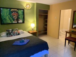 a bedroom with a bed and a bathroom at Can Jam Retreat in Negril