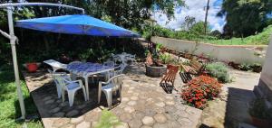 een patio met een tafel en stoelen en een parasol bij Kitnet no Sul de Minas in Soledade de Minas