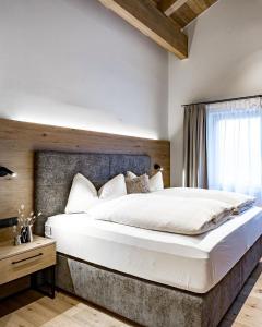 a bedroom with a large white bed with a window at Alpenchalet Tirol in Längenfeld
