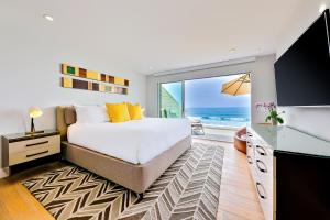1 dormitorio con 1 cama y ventana grande con vistas al océano en Encinitas Seabluffe Oceanfront Condo en Encinitas