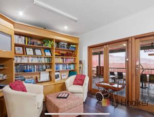 a living room filled with furniture and bookshelves at Pemberton Lodge in Pemberton