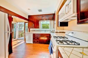 a kitchen with wooden cabinets and a stove top oven at Charming Hillcrest Craftsman in San Diego