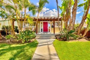 uma casa com uma porta vermelha e palmeiras em Charming Hillcrest Craftsman em San Diego