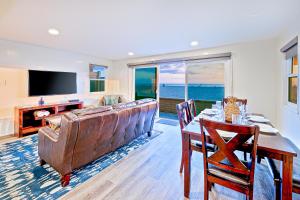 a living room with a table and a couch and a television at Wonderful Beachfront Beach house in Newport Beach