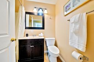 a bathroom with a toilet and a sink and a mirror at Disney Getaway in Anaheim +30 photos