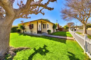 a yellow house with a white fence and a green yard at Disney Getaway in Anaheim