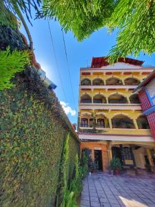 un gran edificio amarillo con balcones en un lateral en Hotel Santa Maria, en Panajachel